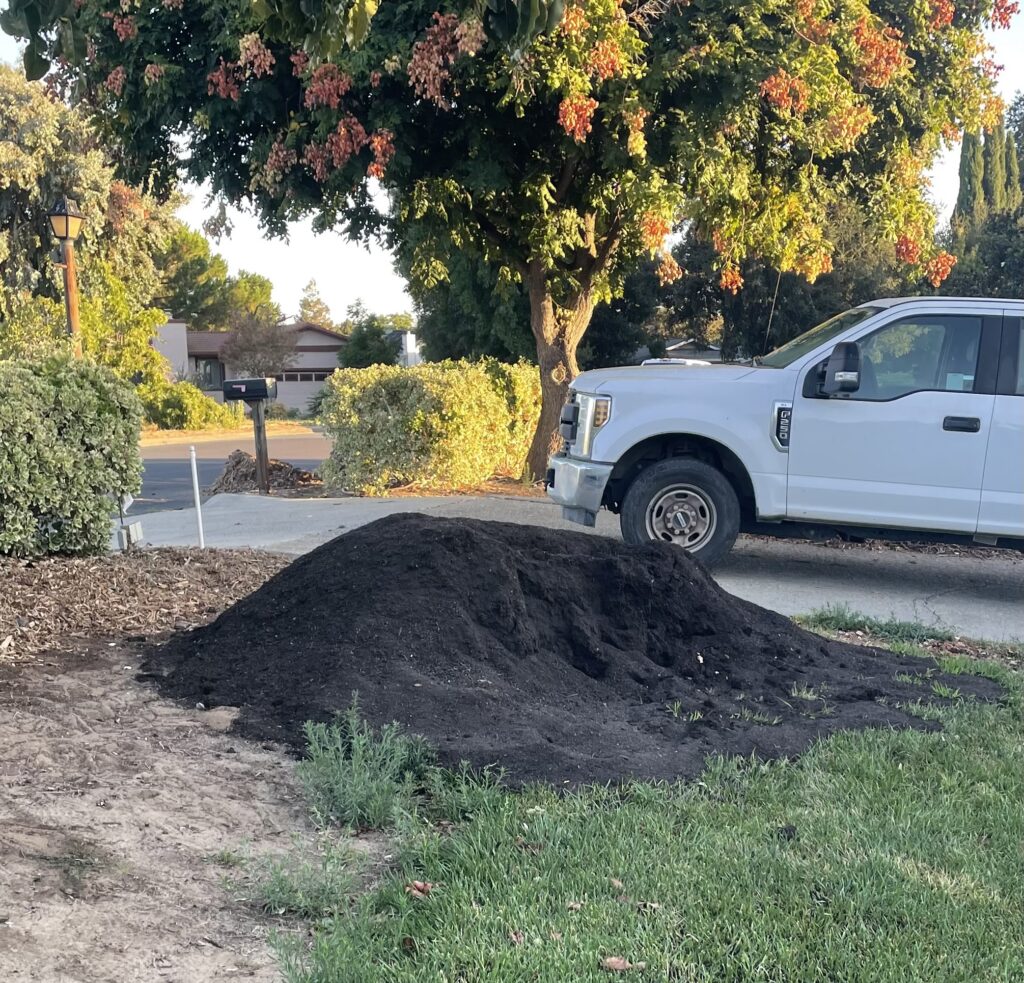 Dark compost pile delivered beside the front lawn at our Oakley property